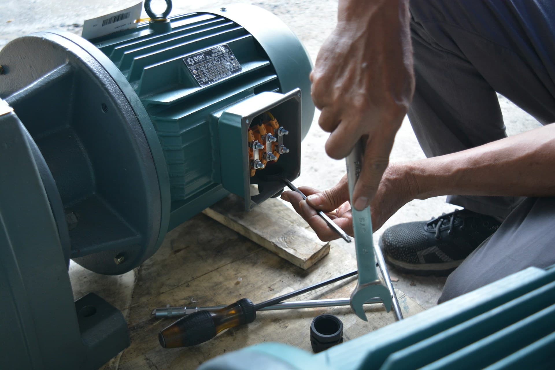 Técnico revisando la caja de conexiones de un motor industrial